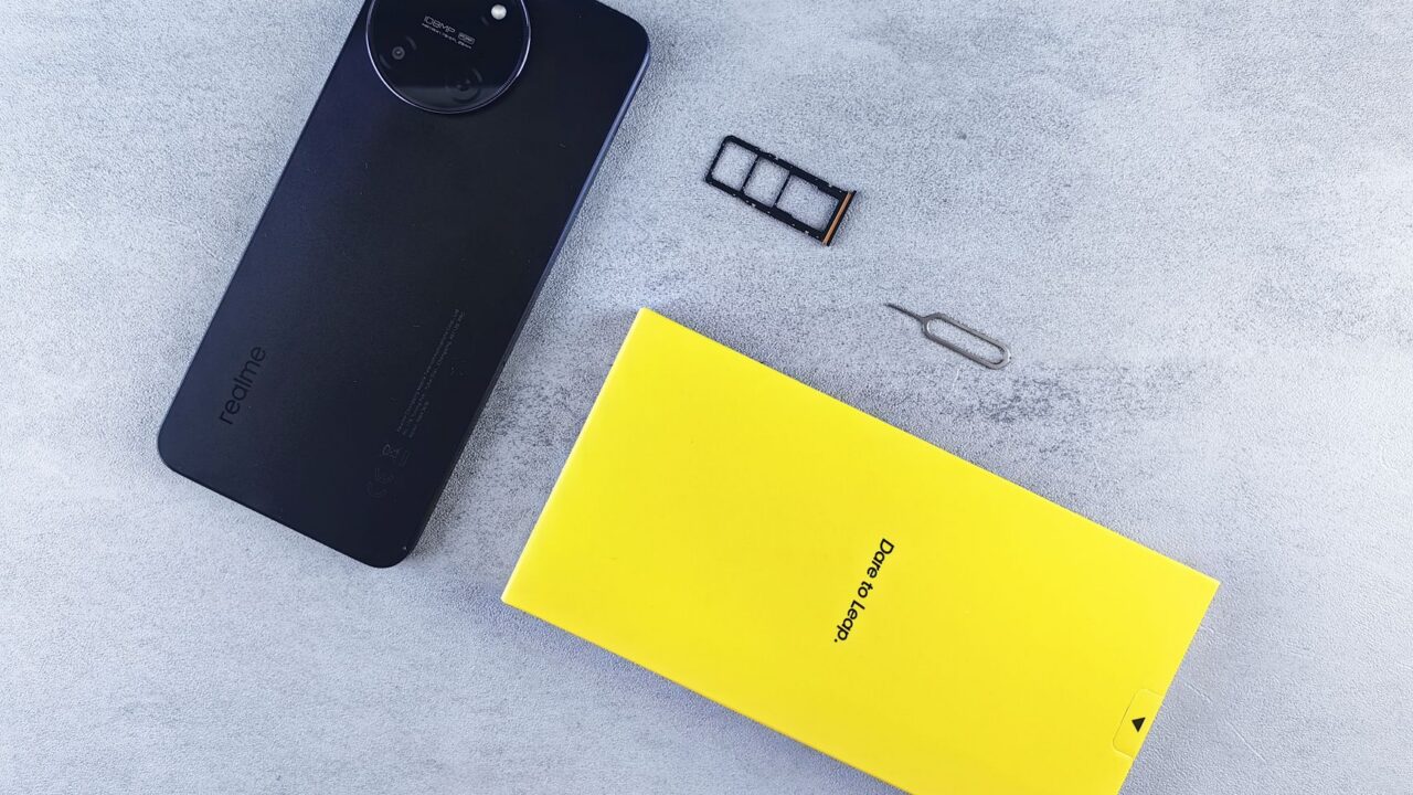 Telefon mobil așezat pe un birou, cu sertarul pentru cartela SIM scos și gol alături