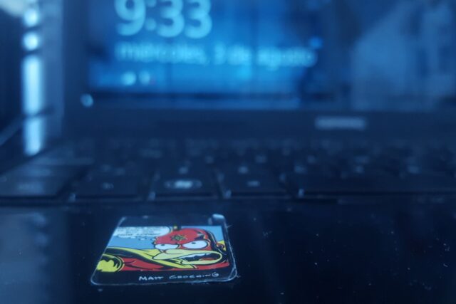 Laptop deschis pe un ecran de autentificare, alături de un lacăt metalic, simbol al protejării parolelor