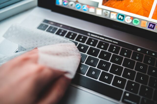 Laptop deschis pe un birou, în timpul verificării performanței și curățării sistemului de operare