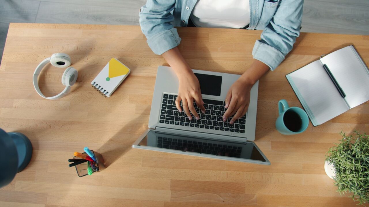 Hard disk extern conectat la un laptop pe un birou, folosit pentru copia de siguranță a fișierelor